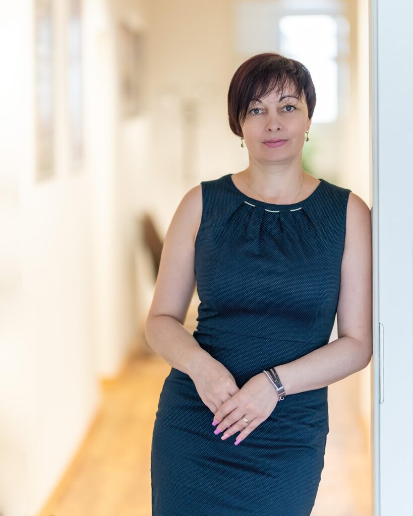 Confident woman in blue dress indoors reflecting Female CEO statistics 2025.