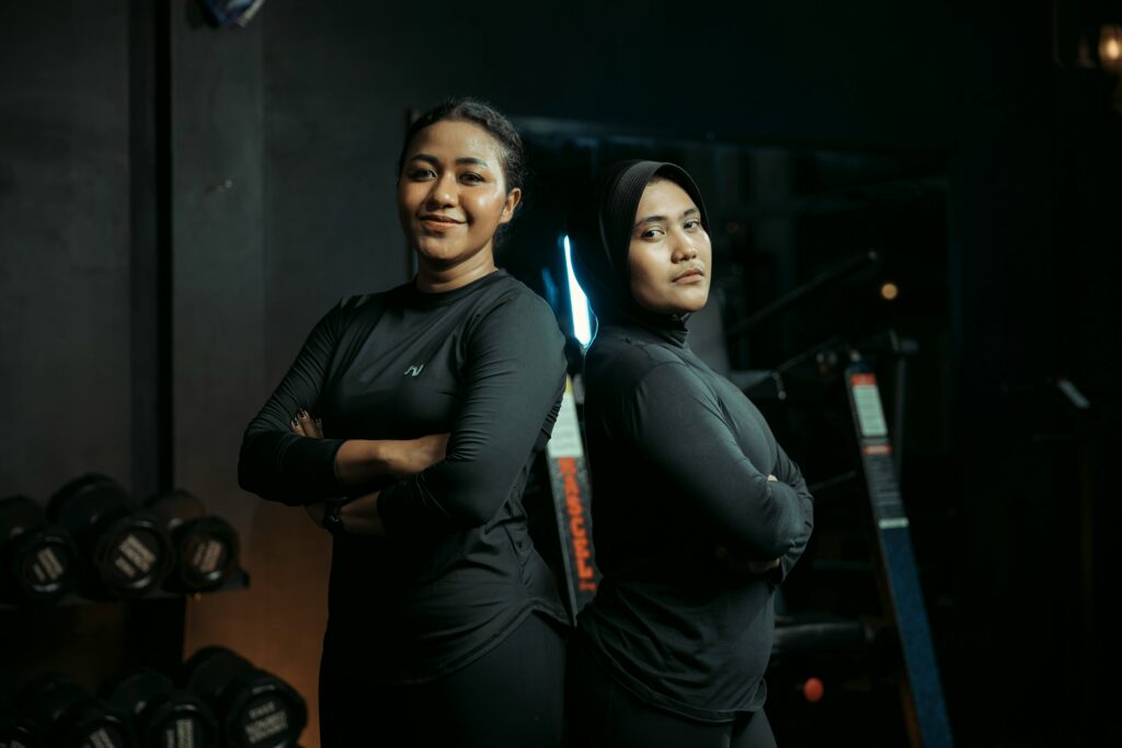 Two women back to back in all black reviewing a women leadership mentorship platform like WomenCEO