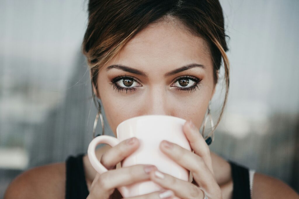 Professional woman drinking coffee while frustrated about Chief waitlist being too long, considering Chief membership alternative