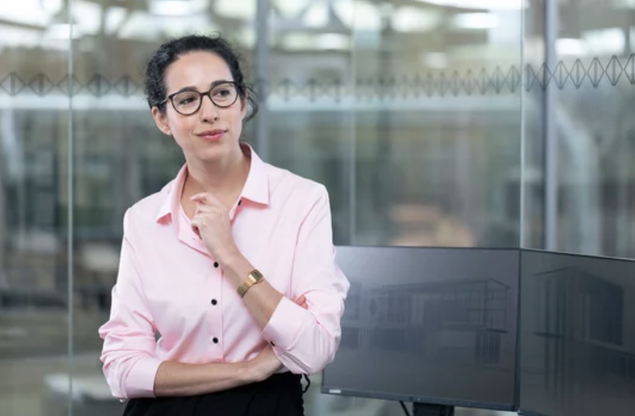 Businesswoman in pink shirt and glasses attending best women conferences 2026