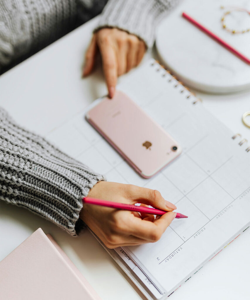 Close-up of a woman planning her week with an online accountability partner, emphasizing structure and commitment