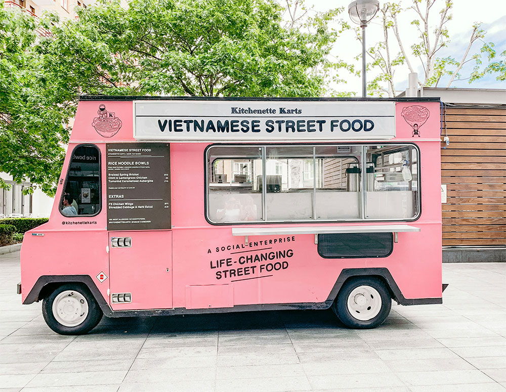 Pink food truck displaying life changing street food sign, exemplifying how entrepreneurs solve problems through innovative food service and entrepreneurs economic growth