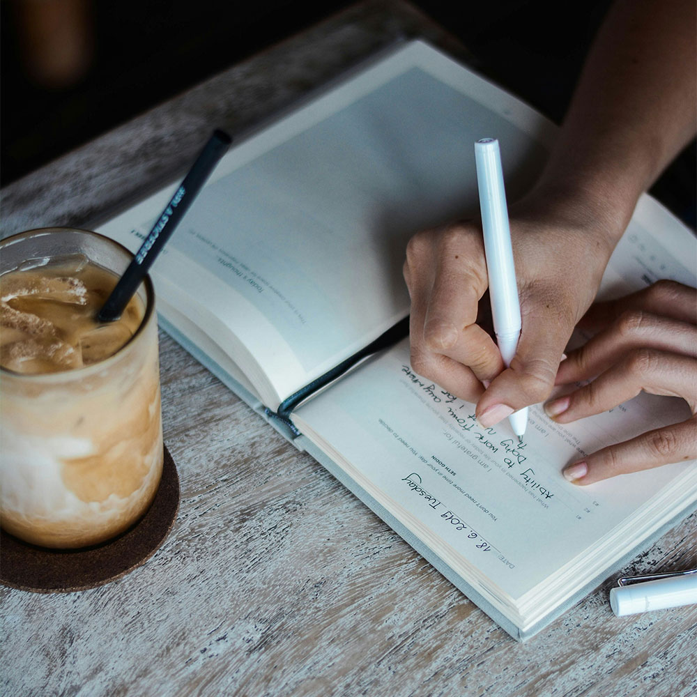Professional woman taking notes on community transformation strategies, studying the role of entrepreneurs in society for local development planning