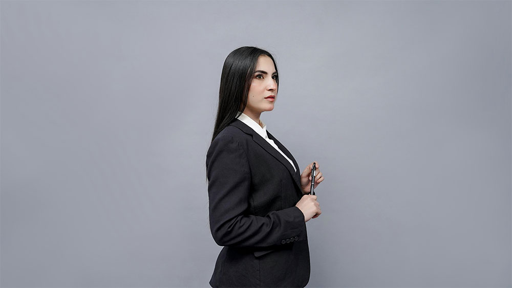 Woman alone standing at a window contemplating Chief vs LinkedIn for her career growth