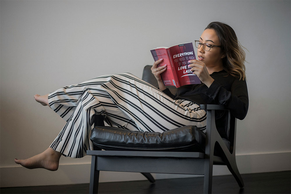 Woman reading on black chair in a smart networking event outfit